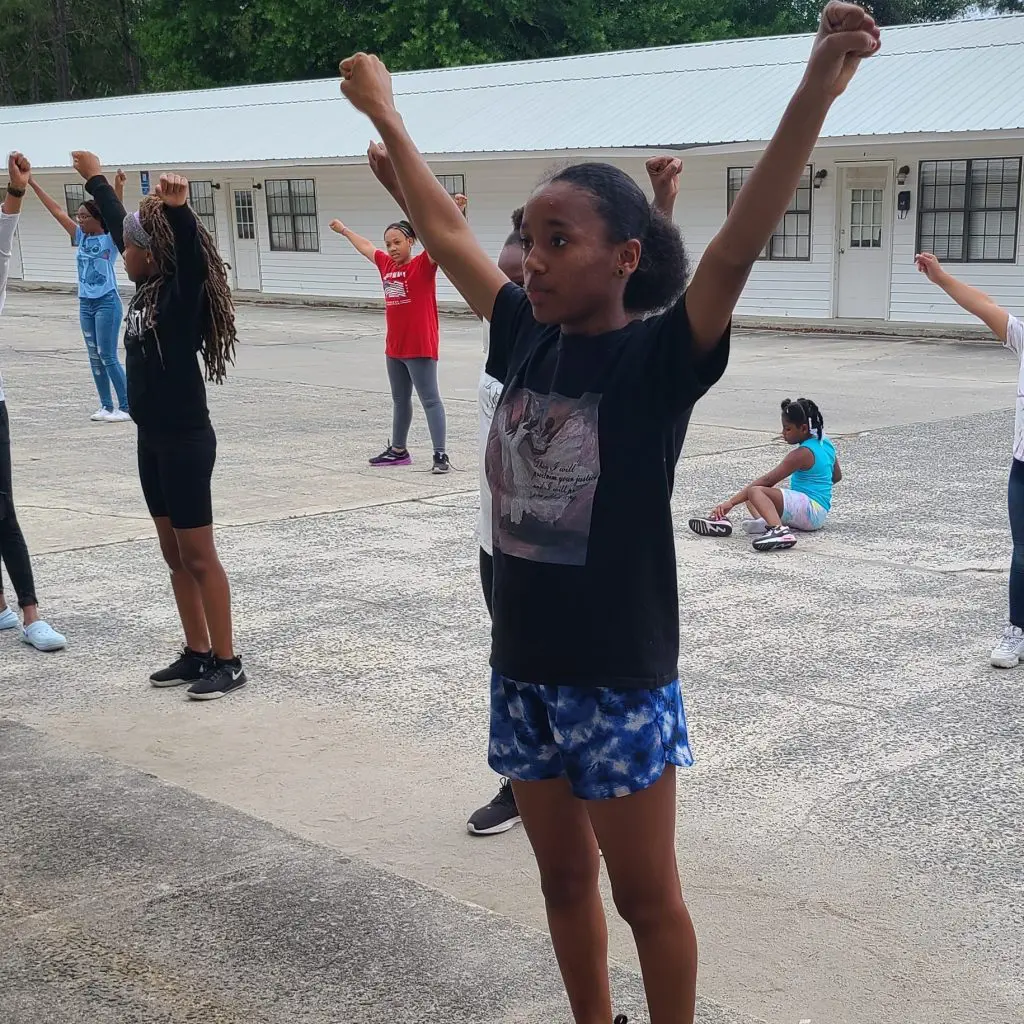 Youth competitive cheerleader cheering in practice with team with All Kids Play youth sports financial assistance grant