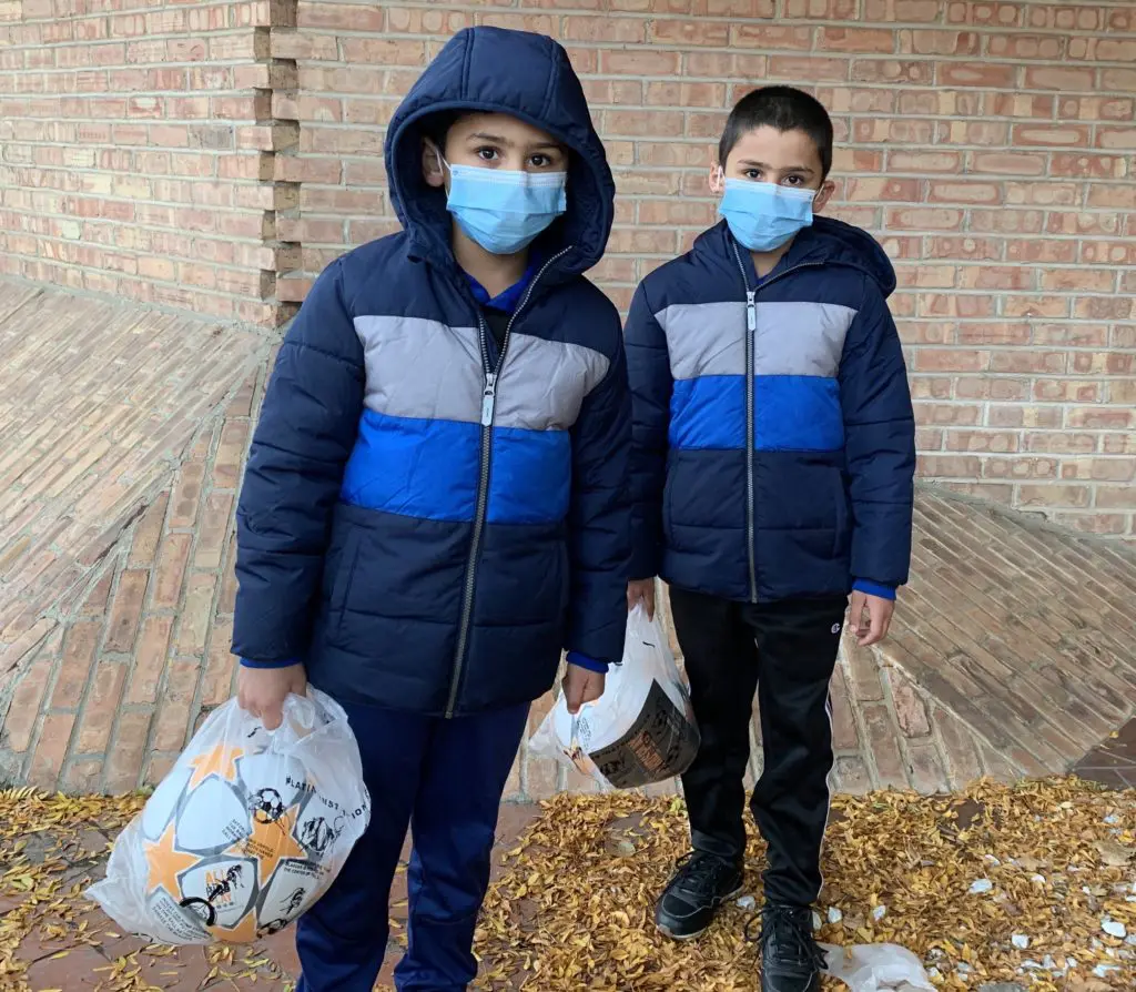 Set of twins with soccer balls at RefugeeOne in Chicago at All Kids Play Bounce Back sports ball giveaway