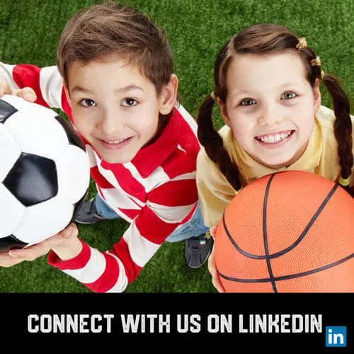Youth sports boy soccer player and girl basketball player holding balls up and smiling