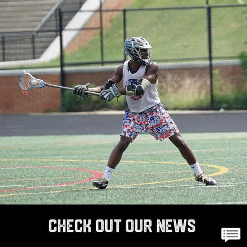 African American teenage boy youth sports lacrosse player passing a lacrosse ball with a stick on a field
