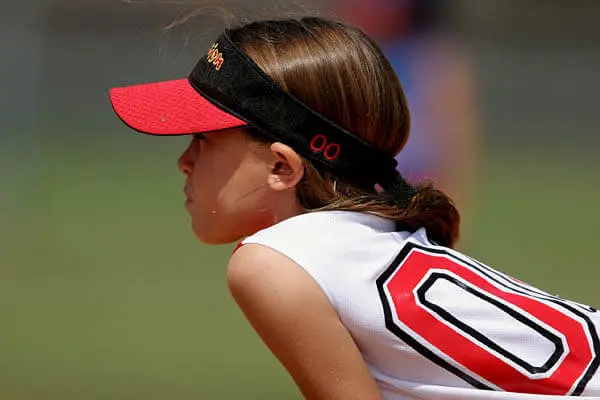 Youth sports girl softball player ready to field a softball during a game.